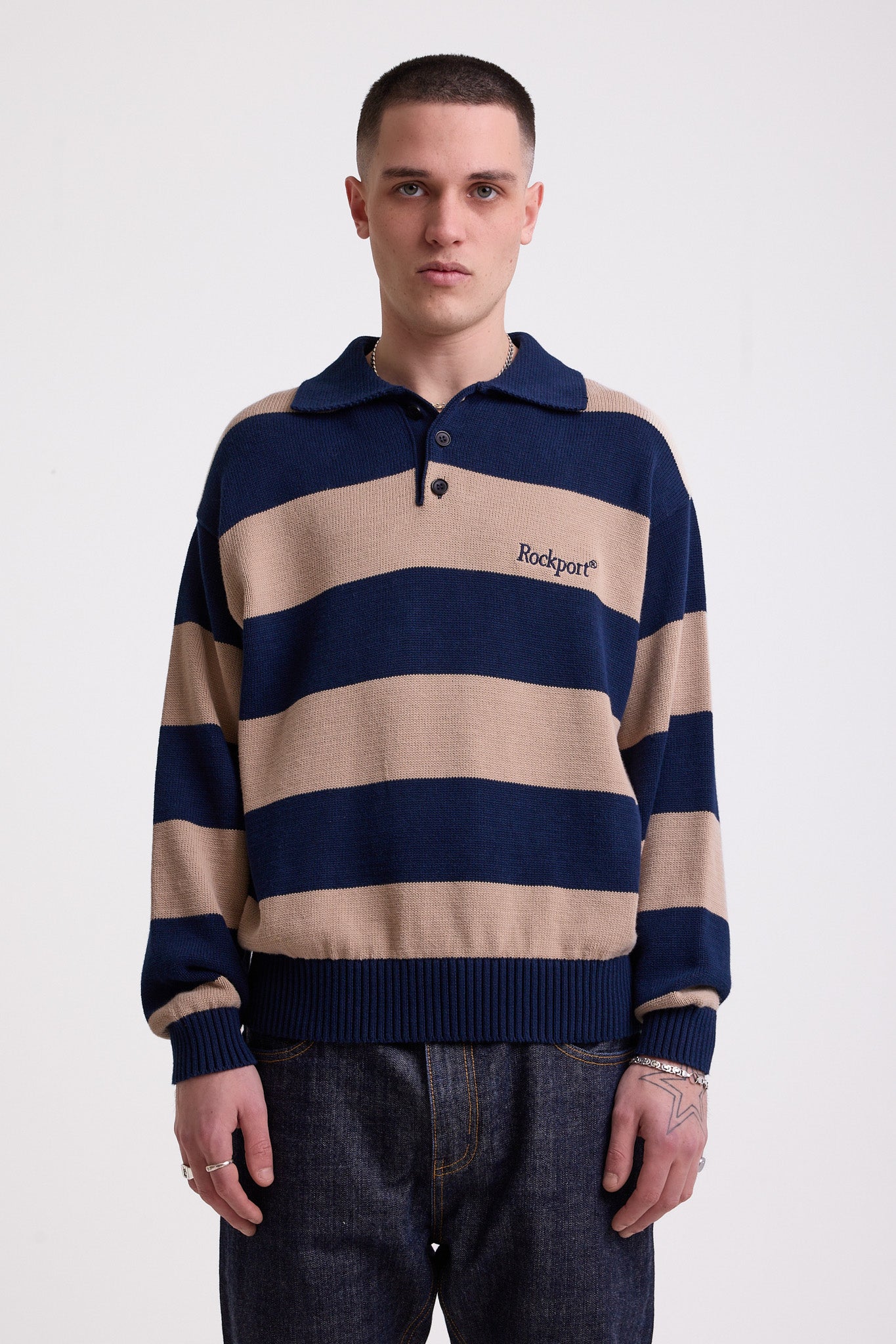 Navy and stone stripe knit polo jumper with Rockport embroidery logo at chest, worn by a model