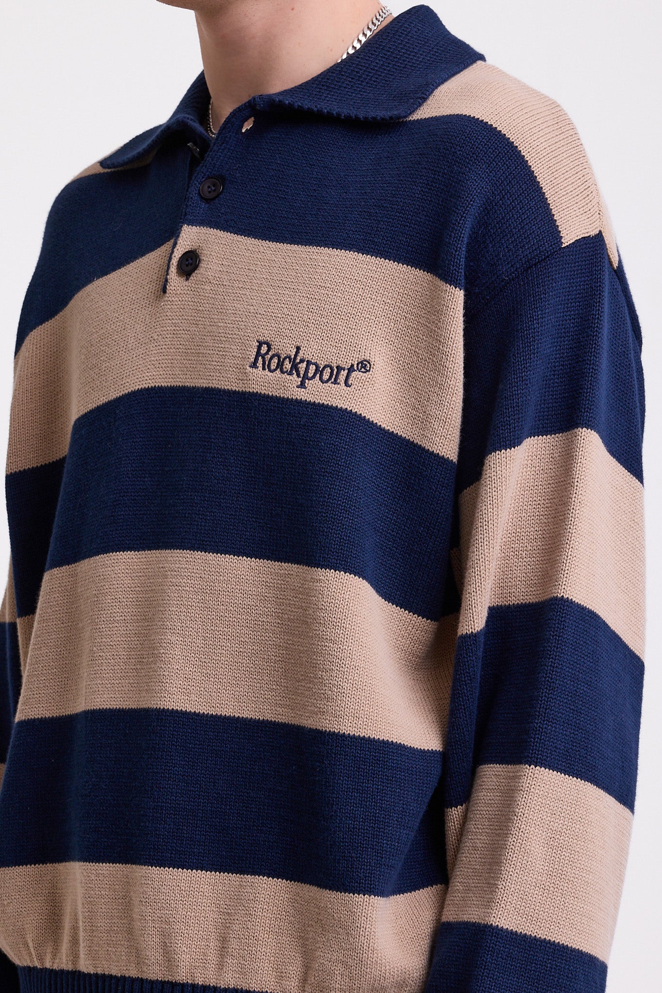 Navy and stone stripe knit polo jumper with Rockport embroidery logo at chest, worn by a model
