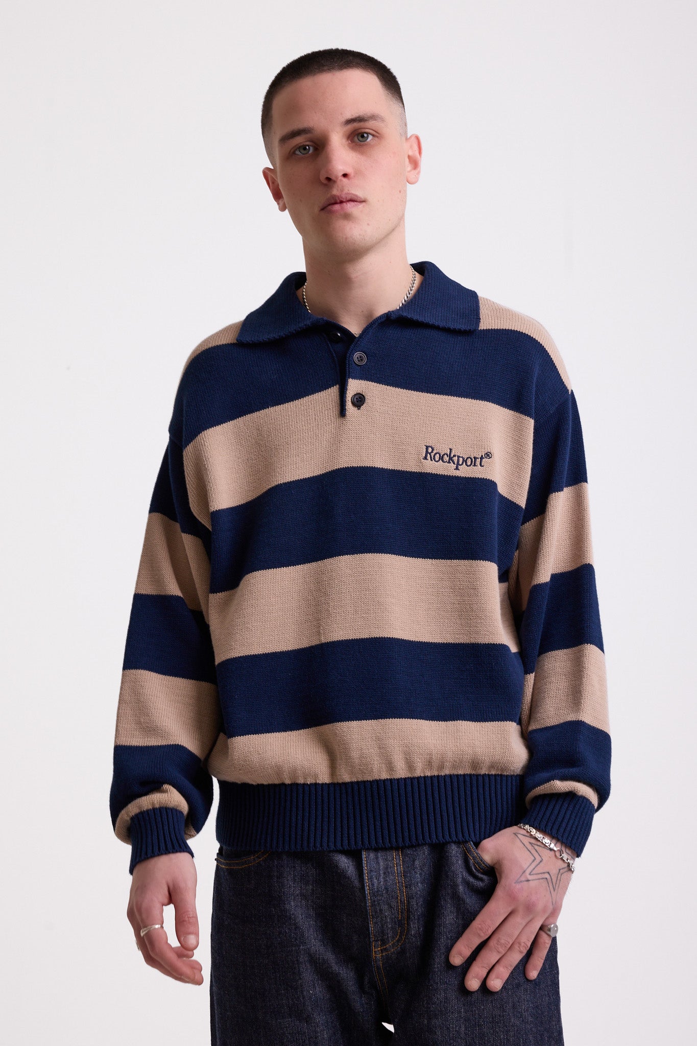Navy and stone stripe knit polo jumper with Rockport embroidery logo at chest, worn by a model