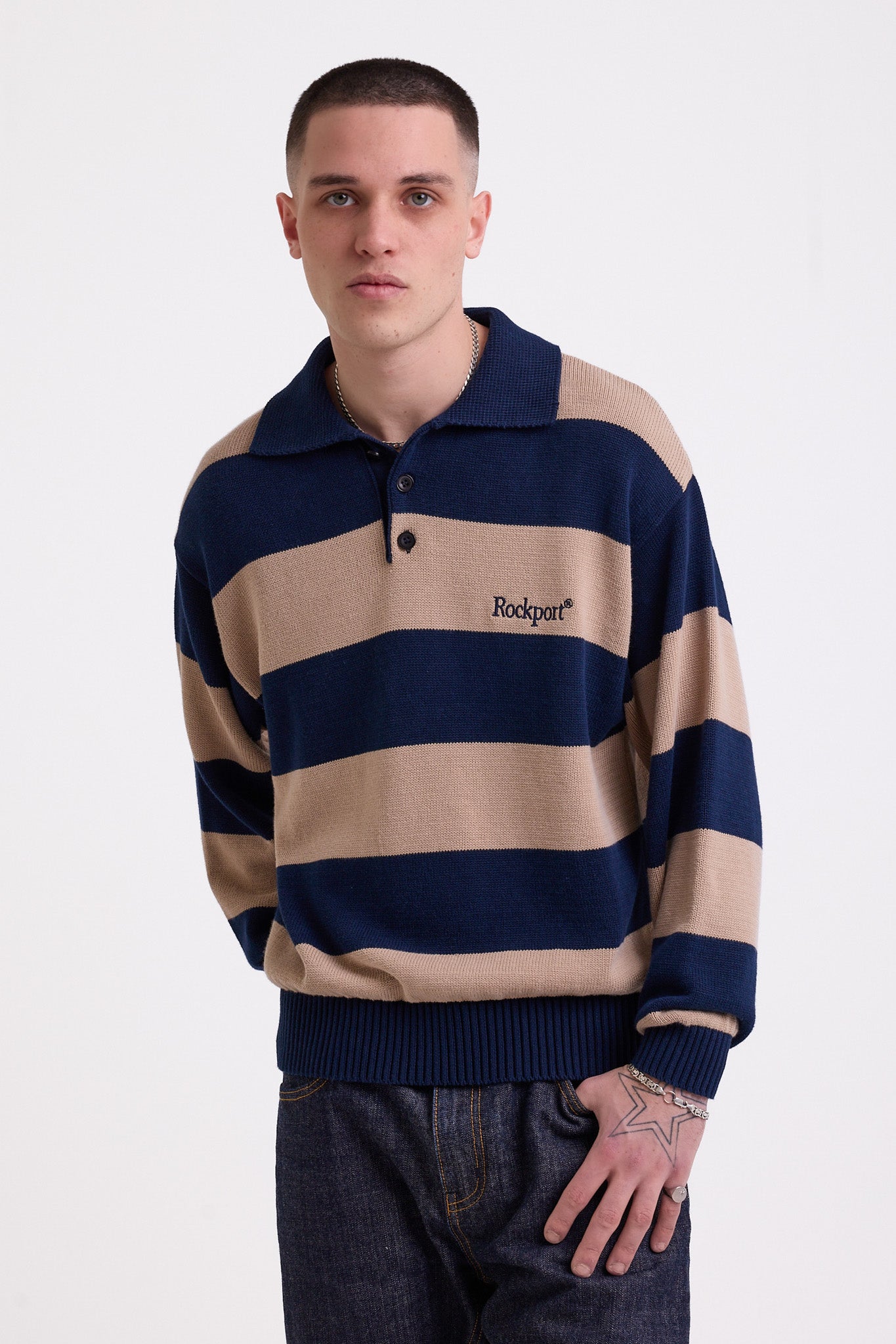 Navy and stone stripe knit polo jumper with Rockport embroidery logo at chest, worn by a model