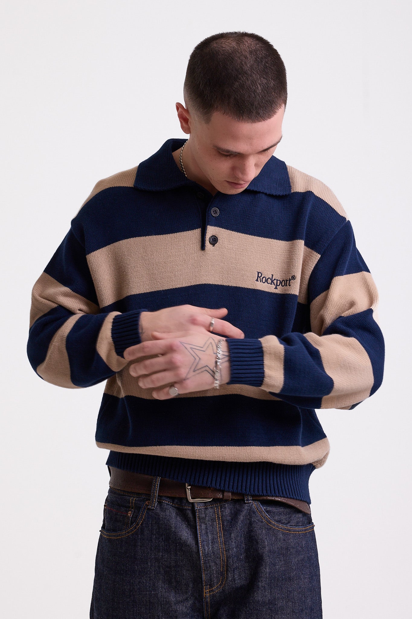Navy and stone stripe knit polo jumper with Rockport embroidery logo at chest, worn by a model