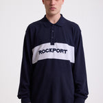 Navy long sleeve pique polo shirt with contrast chest panel and appliqué Rockport logo, worn by model