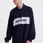 Navy long sleeve pique polo shirt with contrast chest panel and appliqué Rockport logo, worn by model