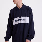 Navy long sleeve pique polo shirt with contrast chest panel and appliqué Rockport logo, worn by model