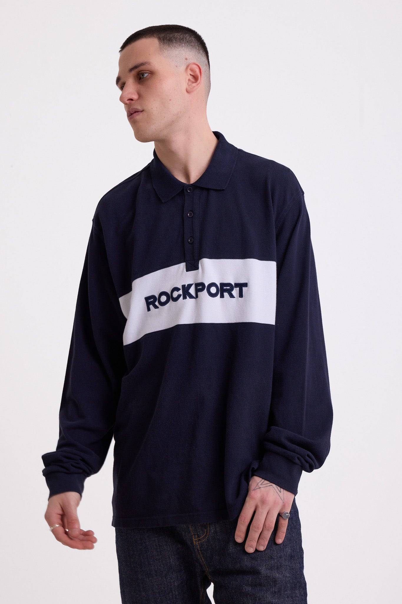 Navy long sleeve pique polo shirt with contrast chest panel and appliqué Rockport logo, worn by model