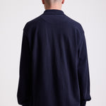 Navy long sleeve pique polo shirt with contrast chest panel and appliqué Rockport logo, worn by model