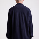 Navy long sleeve pique polo shirt with contrast chest panel and appliqué Rockport logo, worn by model