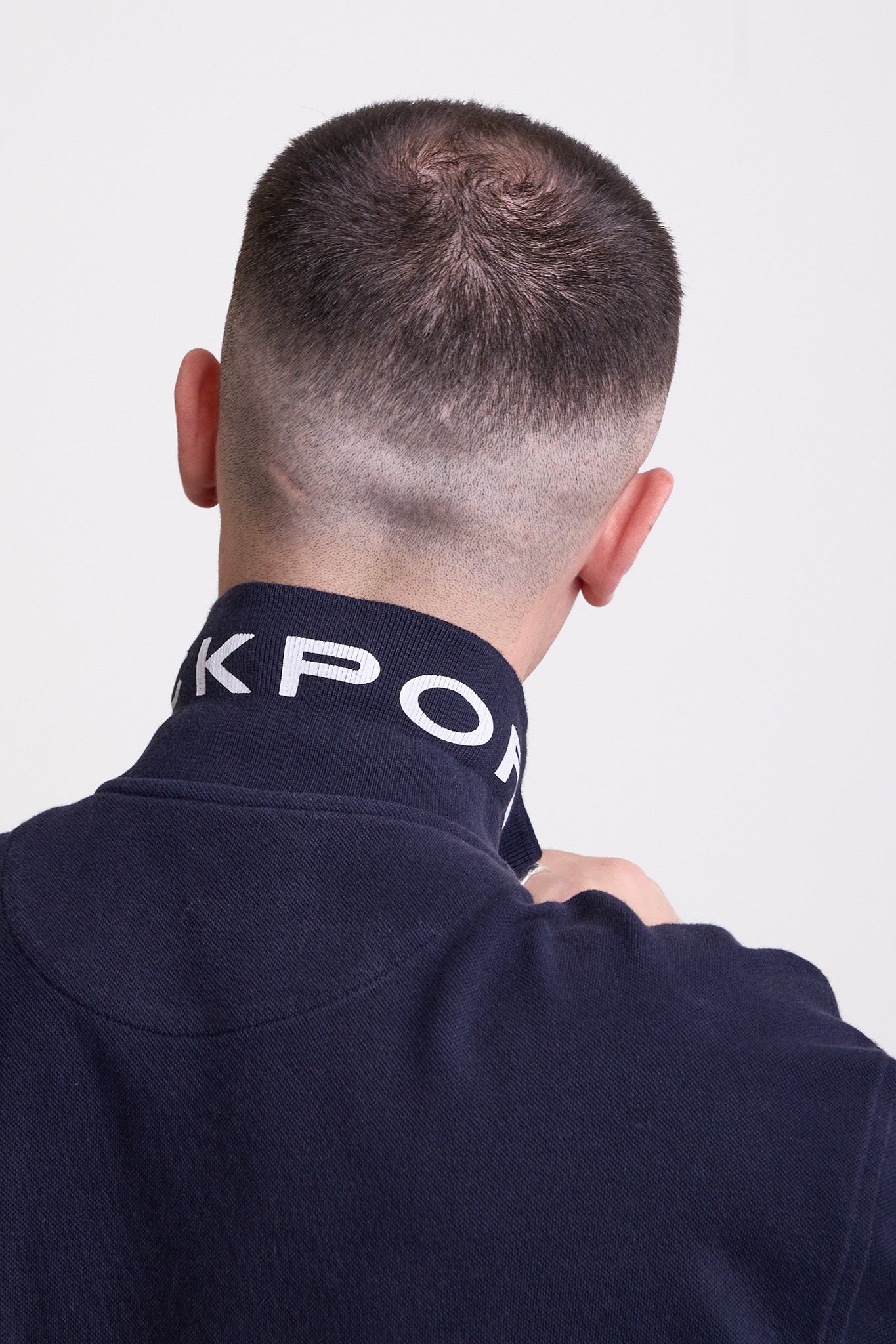 Navy long sleeve pique polo shirt with contrast chest panel and appliqué Rockport logo, worn by model