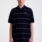 Navy and white striped pique polo shirt with embroidered Rockport logo, worn by model