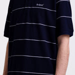Navy and white striped pique polo shirt with embroidered Rockport logo, worn by model