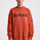 Burnt orange cotton crew neck sweatshirt with embroidered Rockport logo and american flag at chest, worn by model