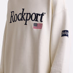 Ecru cotton crew neck sweatshirt with embroidered Rockport logo and american flag at chest, worn by model