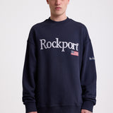 Navy cotton crew neck sweatshirt with embroidered Rockport logo and american flag at chest, worn by model