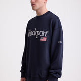 Navy cotton crew neck sweatshirt with embroidered Rockport logo and american flag at chest, worn by model