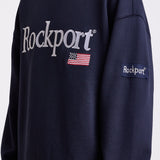Navy cotton crew neck sweatshirt with embroidered Rockport logo and american flag at chest, worn by model
