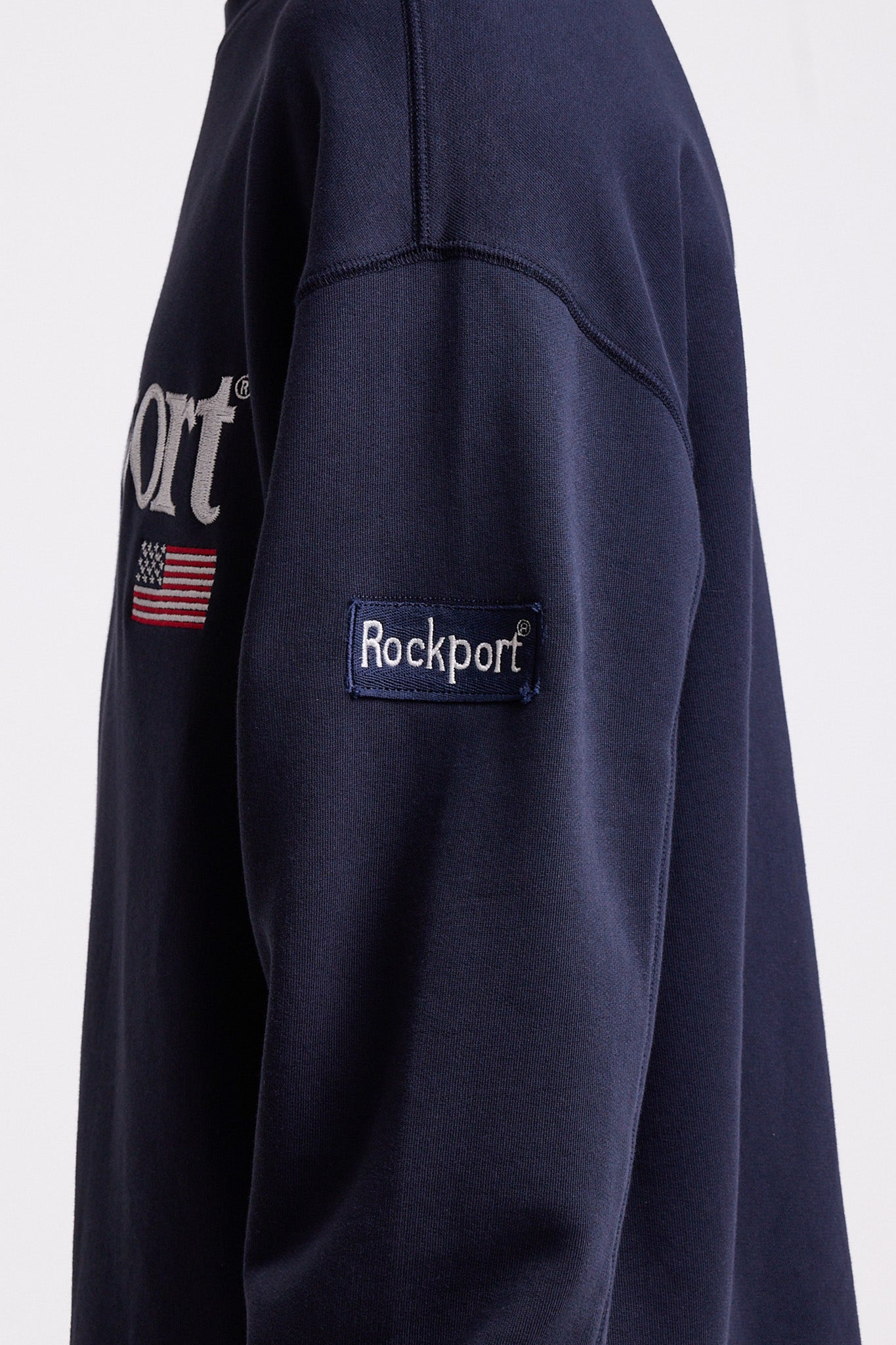 Navy cotton crew neck sweatshirt with embroidered Rockport logo and american flag at chest, worn by model