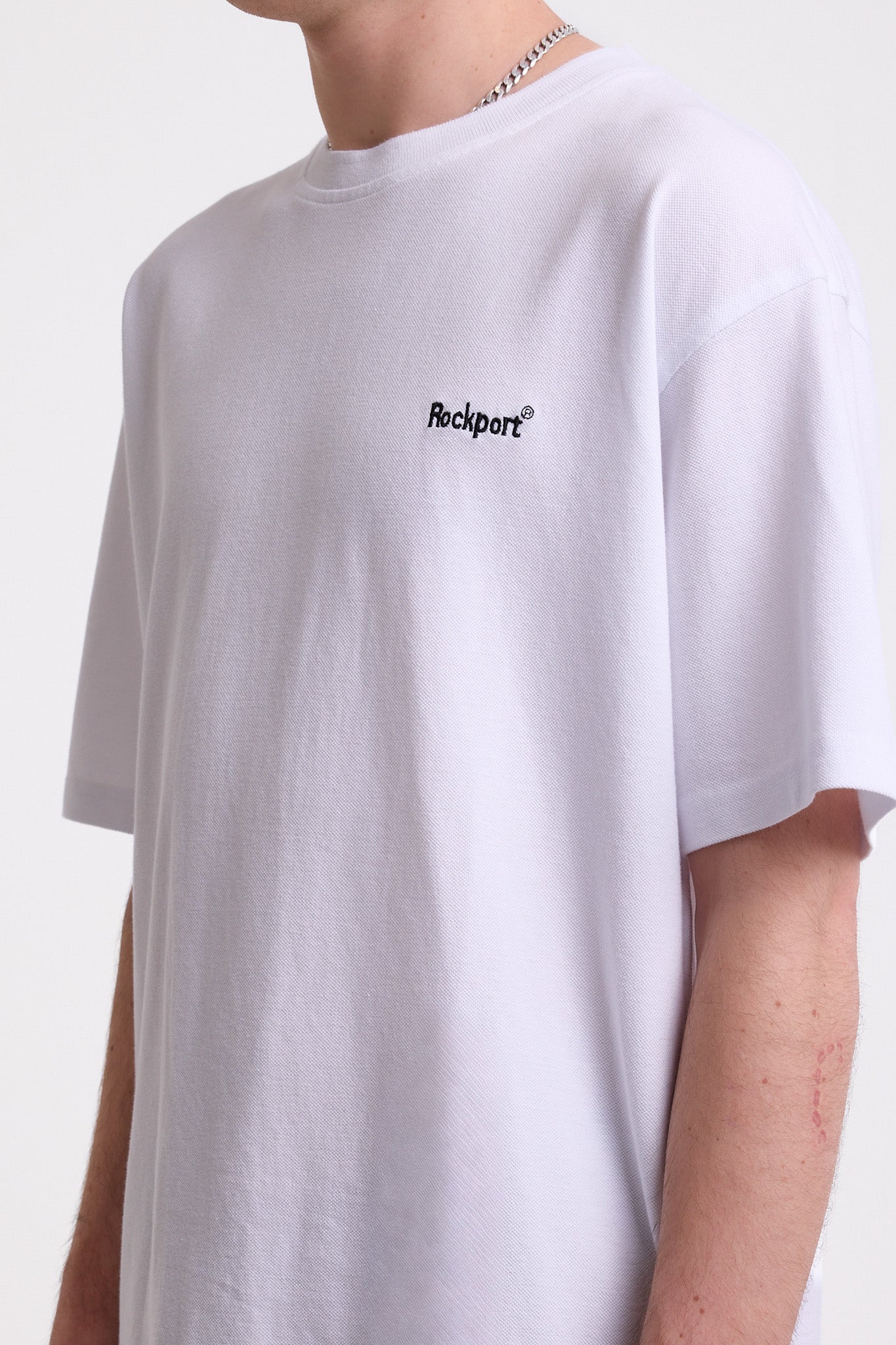 White pique crew neck t-shirt with navy Rockport embroidery, worn by model